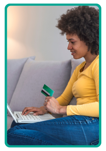 Woman using computer and holding a credit card